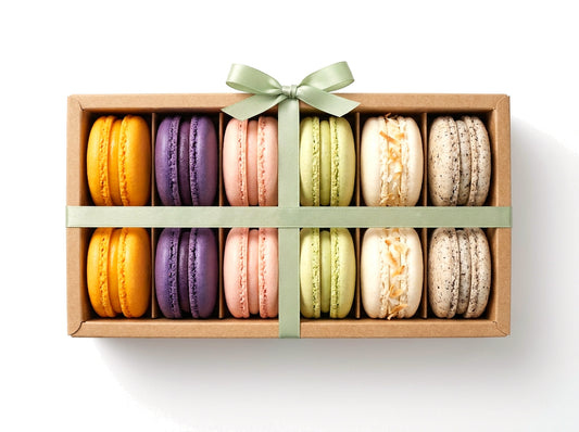 The Connoisseur — a dozen gourmet French macarons in a kraft box with a sage green ribbon bow