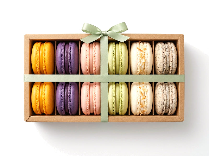 The Connoisseur — a dozen gourmet French macarons in a kraft box with a sage green ribbon bow