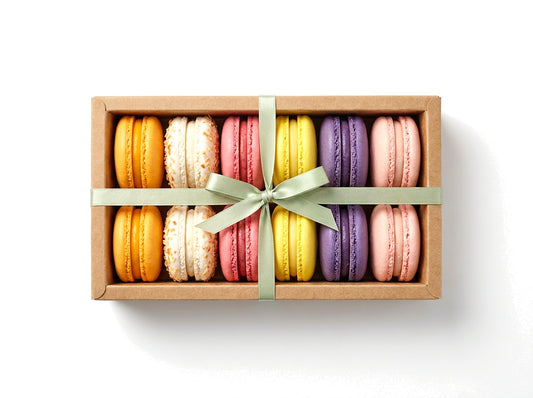 Island & Orchard — a dozen tropical French macarons in a kraft box with a sage green ribbon bow